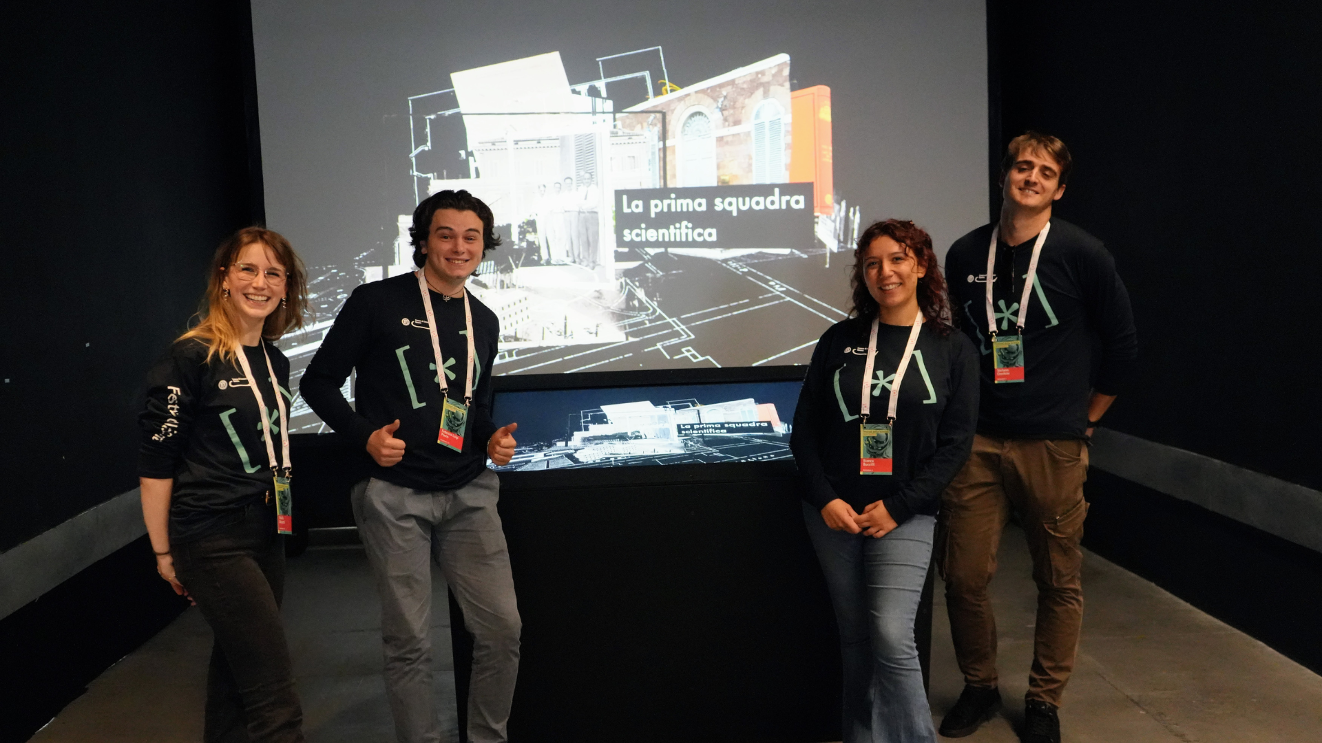 quattro giovani animatori intorno al touch screen della mostra